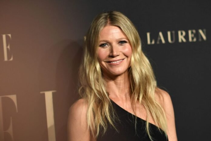 Gwyneth Paltrow smiling in front of a black background